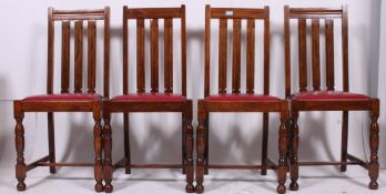 A set of four art deco bar back dining chairs having red vinyl drop seats.