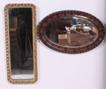 A 1940's oval overmantel mirror along with a gilt framed rectangular mirror. Measures: 99cm x 38cm.