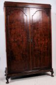 A 1930's Walnut Queen Anne  compactum wardrobe raised on cabriole legs with twin section body