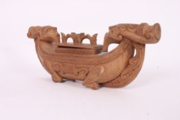 A carved wooden Indonesian feather box i