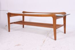 A vintage teak and glass 1970's retro coffee table having slatted magazine rack to the underside