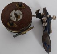 A vintage early 20th century wooden fishing reel being unnamed together with a small metal