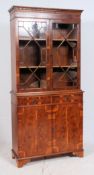 A Georgian style yew wood library bookcase cabinet having astragal glazed cabinet over drawers and