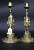 A pair of Regency brass anthropomorphic candlesticks having figural stems raised on socle plinth