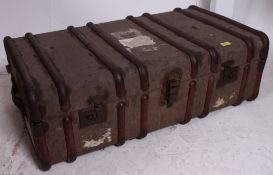 A vintage early 20th century canvas and wooden bound steamer trunk having hinged centre.