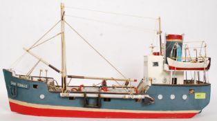 A vintage scratch built model of a ship being hand painted.
