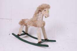 A 20th century wooden made rocking horse, appearing to be hand made with painted features.