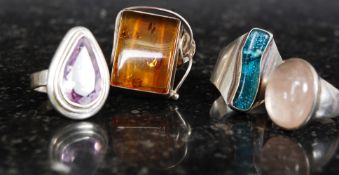 A selection of 4 silver dress rings set with amber, amethyst and rose quartz stones Total weight.