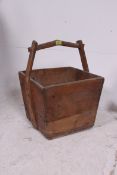 A vintage style large wooden trug of square tapering form having handle atop