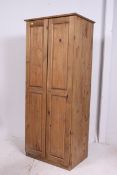 A contemporary pine upright single locker wardrobe. Twin full length doors housing storage within.