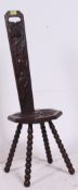 An early 20th century Welsh carved oak spinning chair being raised on turned legs having hollow