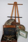 An Artists wooden palette together with a collection of oils and paints in a wooden case along with