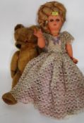 A large retro doll dating from the 60's along with a good sized vintage straw filled teddy bear