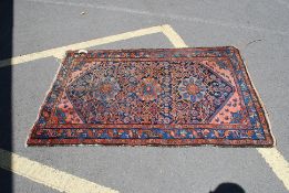 A Turkish hand woven 20th century Hereke style rug having red and blue ground with flower head