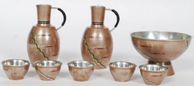 A Japanese Saki set of metal construction consisting of two jugs, drinking bowls,