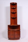 A retro 1960's teak wood corner cabinet having qtr panel lower cupboard over bookcase shelving
