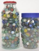A good collection of vintage marbles of varying ages and sizes contained within two glass jars