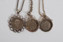 A collection of three white metal (stamped 925, indicating silver content ) mounted coins necklaces.