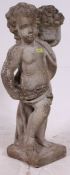 A large reconstituted stone garden ornament of a cherub raised on square applied plinth mount