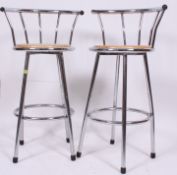 A pair of  20th century contemporary bar stools having chrome frames and back and wooden seats.