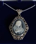 A decorative white metal cameo set pendant necklace.