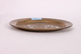 A 20th century Indian brass and white metal (possibly silver) inlaid worked dish.