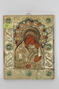 A 20th century Russian icon of larger proportions being decorated with coloured stones and raised