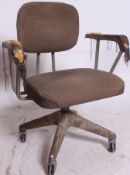 A mid 20th century Industrial metal office swivel chair having original castors to the quadruped
