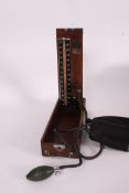 A vintage blood pressure machine sphygmomanometer within the original wooden case with makers