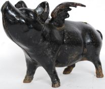 A vintage style cast iron flying pig money box in the form of a smiling pig.