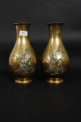 A pair of Meiji period ? brass vases each vase embellished with a foliate leaf design