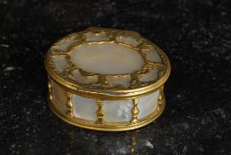A 20th century mother of pearl and fret worked brass work trinket box of oval form with hinged top.