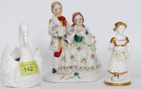 A 19th century continental glazed figurine of a girl together with a Victorian glazed ceramic swan