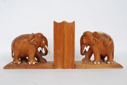 A pair of mid 20th century carved wooden bookends in the form of elephants having secret