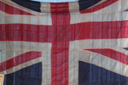 An old large vintage panel stitched Union Jack flag having rope and toggle ends.