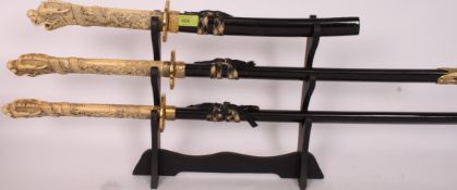 A 20th century set of graduating oriental Samurai swords - each with faux ivory handles, inset eyes.