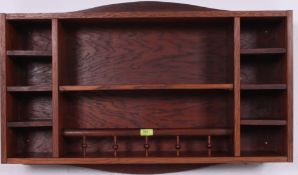 A 20th century wooden wall hanging spice rack cabinet having spindle gallery centre with shelves to
