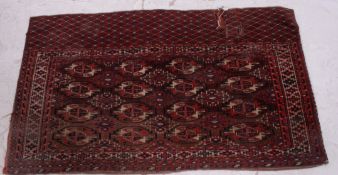 An early 20th century handwoven rug having red ground with geometric design to borders of the the