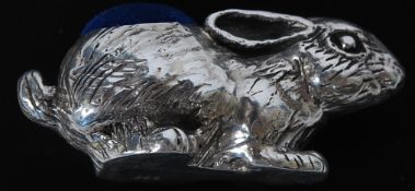 A white metal ( stamped 925 - indicating silver ) pin cushion in the form of a rabbit.