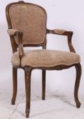 A 20th century French fauteuil armchair with carved decoration and reeded legs with show wood