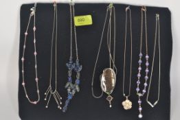 A collection of eight necklaces, all mounted on to a display board containing Silver,