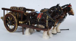 Two 20th century Staffordshire china horses, along with a wooden cart with barrels. No makers marks.