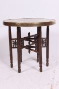 An Islamic style brass top folding oak merchants table.