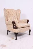 A contemporary Georgian antique style wingback armchair raised on mahogany cabriole legs with pad