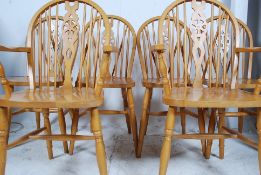 A set of 20th century Windsor style wheelback dining chairs raised on turned legs having saddle