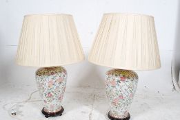 A pair of large contemporary Chinese famille rose table lamps in the form of vases raised on wooden