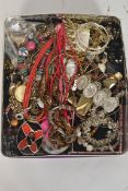 A tin of costume jewellery to include necklaces,
