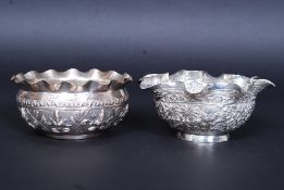 A decorative Indian silver finger bowl of hammered form having embossed decoration together with a
