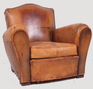 A 1930's Art Deco French Leather Club Armchair raised on squared feet with barrel arms and cloud