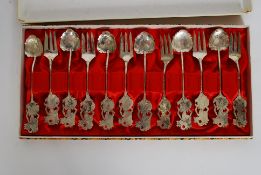 A cased set of Chinese white metal silver plated spoons and forks having decorative handles.